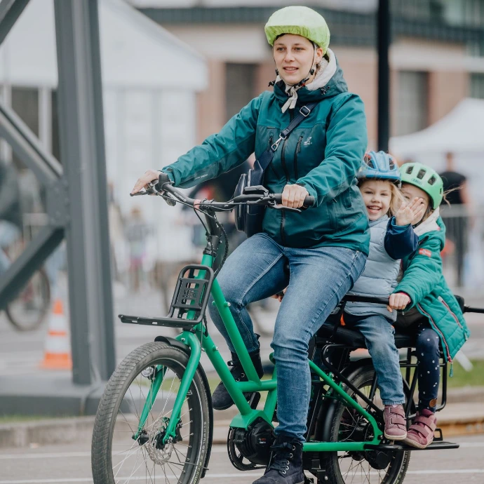 Eine Frau fährt zwei Kinder auf einem Veloe multi lungo