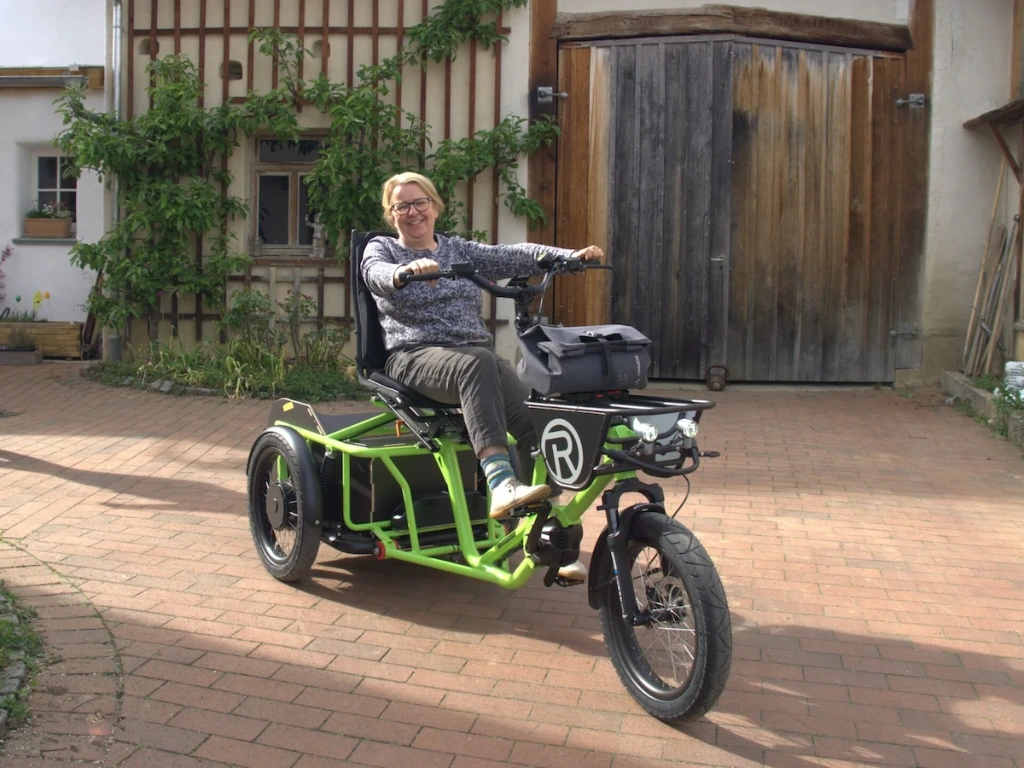 A woman is sitting on a Radkutsche COMPANION tricycle.